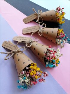 three cones with flowers tied to them on a table