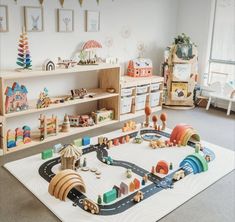 a child's play room with toys and bookshelves on the floor, including a toy train set