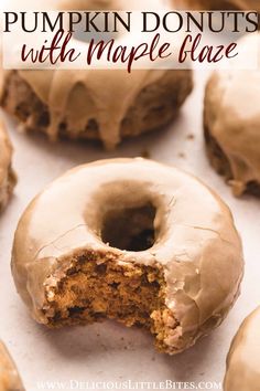 pumpkin donuts with maple glaze are on a baking sheet and have been cut in half