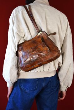 Step back in time with this authentic 1970s original brown leather shoulder bag, a vintage treasure that exudes timeless style and sophistication. Crafted from premium quality leather, this exquisite accessory has aged like fine wine, boasting a rich patina that only enhances its allure. The warm brown hue of the leather is reminiscent of a well-loved heirloom, inviting touch with its supple texture and visible grain that tells a story of decades past. The bag features a robust thick metal zippe Leather Handbags Handmade, Like Fine Wine, Italian Bags, Brown Leather Shoulder Bag, Vintage Leather Bag, Fine Wine, Vintage Bags, Vintage Accessories, Vintage Leather