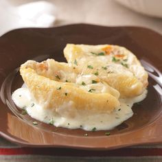 some food is on a brown plate with white sauce and green garnishes