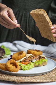 a person is eating a sandwich on a plate