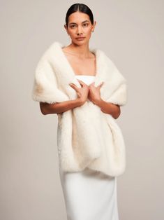 a woman is wearing a white fur stole