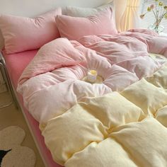 an unmade bed with pink and yellow sheets