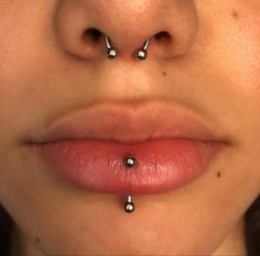 a woman's nose has three piercings on it