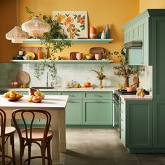 a kitchen filled with lots of green cabinets next to a counter topped with oranges