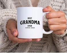 a woman holding a white coffee mug with the words best grandma ever