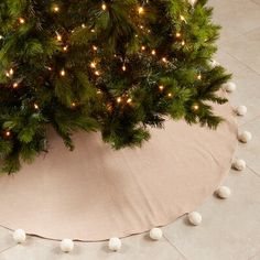 a christmas tree skirt with white balls on it