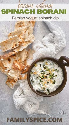 a bowl of dip next to pita chips