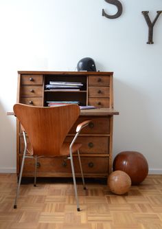 a wooden desk and chair in front of a wall with the letter y on it