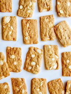 cookies and almonds are arranged in rows on a white surface, including one cookie