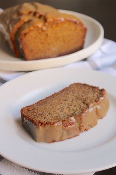 two plates with slices of cake on them and one plate has a loaf of bread