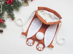 an orange and white bunny bag sitting on top of a table next to christmas decorations