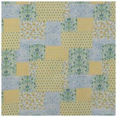 a yellow and blue patchwork quilt with flowers on the front, in different colors