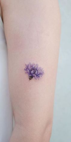 a purple flower tattoo on the left arm