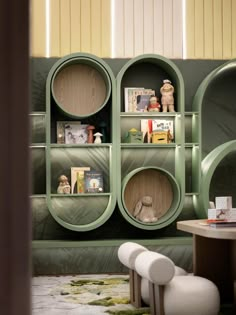 a room with green shelves and white chairs