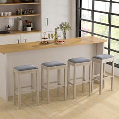 three stools sit at the bar in this modern kitchen