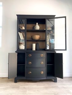 a black china cabinet with glass doors and drawers