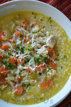 a bowl of soup with carrots, celery and parmesan cheese