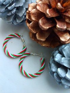 "Tiny beads in green, white, and sparkling metallic red were woven to encase these silver-plated, nickel-free hoop earrings in candy-cane inspired spirals.    They are for pierced ears, and have latch-back closures, so they stay very securely in place when worn.  Approximately 1 1/2\" from side to side and top to bottom.  A fun and original way to add to your holiday celebrations this year!" Festive Beaded Hoop Earrings With Round Beads, Christmas Beaded Hoop Earrings, Festive Green Hoop Earrings, Red Beaded Hoop Jewelry, Handmade Red Beaded Hoop Earrings, Boho Hoop Earrings, Wanderlust Jewelry, Geometric Bracelet, Beaded Cuff Bracelet