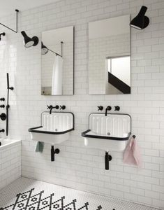 two sinks and mirrors in a white tiled bathroom