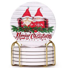 a stack of white plates sitting on top of each other with santa hats and holly wreaths