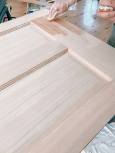 a person that is working on some kind of cabinet door frame with wood in it