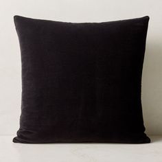 a black pillow sitting on top of a white table