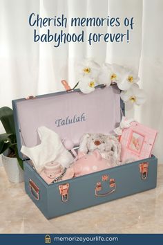 there is a blue suitcase with baby items in it and the words cherish memories of babyhood forever