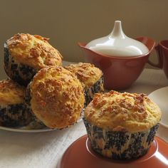 three muffins sitting on a plate next to a cup of milk