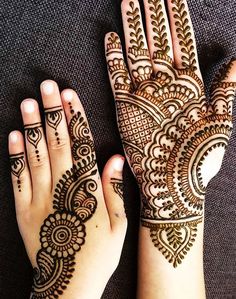 two hands with henna tattoos on them, one is showing off the intricate design