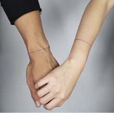 two people holding hands with one hand on the other