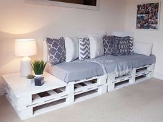 a couch made out of pallets with pillows on it