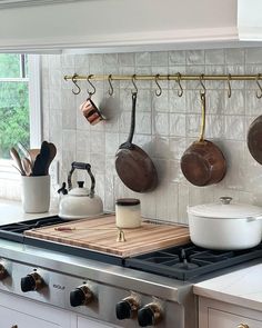 pots and pans are hanging on the kitchen wall