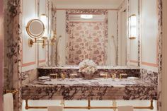 a bathroom with marble counter tops and gold fixtures