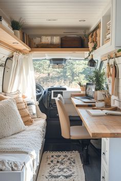 the interior of a camper van with a desk and couch in front of it