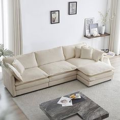 a living room with a large sectional couch and coffee table in front of the window