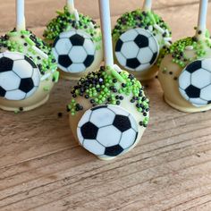 cake pops decorated with soccer balls and sprinkles on a wooden table, ready to be eaten