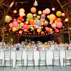 the tables are set up with paper lanterns hanging from the ceiling and chairs around them