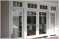 the front door to a house with glass doors on both sides and side windows open