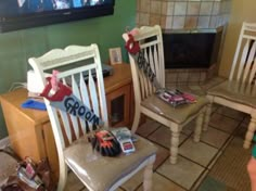 two wooden chairs sitting next to each other in front of a tv