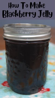 a mason jar filled with blackberries sitting on top of a blue and yellow table cloth