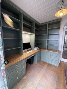 an empty office with lots of shelves and drawers on the wall, along with a computer desk