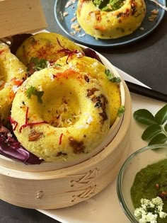 some food is in a wooden bowl on a table with other dishes and utensils