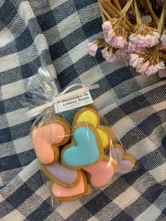 some cookies are wrapped in plastic on a checkered tablecloth with pink flowers and wicker basket