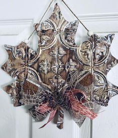 a decorative fall leaf hanging on a door with red and white bowknots