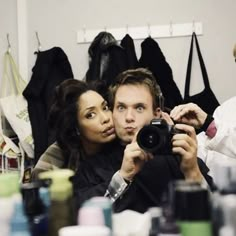 a man and woman taking a selfie in front of a mirror with their camera