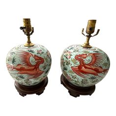 two decorative vases are sitting on top of each other, one with a red dragon painted on it