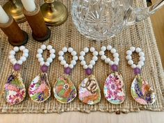 a group of spoons sitting on top of a table next to candles and vases