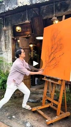 a man is painting on an easel outside